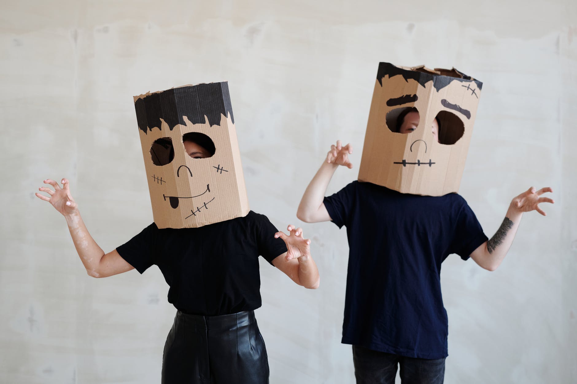 two persons wearing a diy cardboard box mask